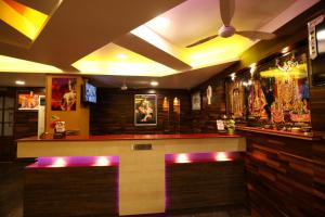 un restaurant avec un bar aux lumières violettes dans l'établissement Hotel Lotus, à Madurai