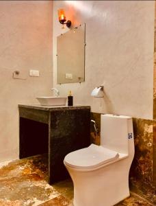 a bathroom with a white toilet and a sink at The WildRocks Jawai in Nāna +29 photos