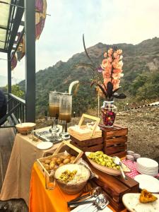 a table with food on it with a view of a mountain at The WildRocks Jawai in Nāna