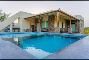a large swimming pool in front of a house at The WildRocks Jawai in Nāna