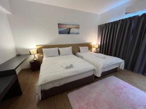 a bedroom with two beds and a large window at Putra Hotel at Mydin Tunjong in Kota Bharu
