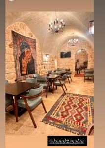 a restaurant with tables and chairs and a painting on the wall at Zenobia Otel in Midyat