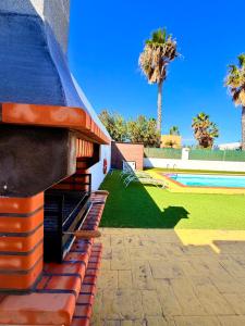 a building with a playground with a slide and palm trees at Villa Solara in Caleta De Fuste
