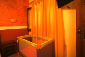 a bathroom with an orange curtain and a tub at Melifilos in Agios Ioannis Pelio