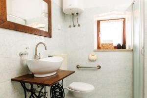 a bathroom with a sink and a toilet at Apartment Valetovi in Štanjel +26 photos