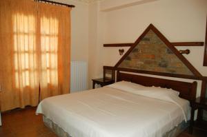 1 dormitorio con cama y pared de ladrillo en Melifilos, en Agios Ioannis