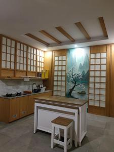 a kitchen with wooden cabinets and a painting on the wall at Agarra Villa in Yogyakarta