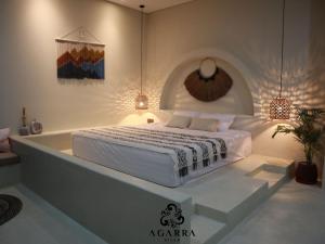 a white bedroom with a bed and a bath tub at Agarra Villa in Yogyakarta +28 photos