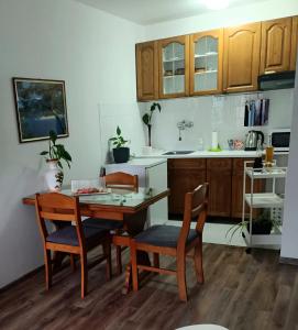 a kitchen with a wooden table and chairs and a table at Apartman Centar in Grude