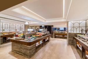a restaurant with a buffet line with food on display at Mercure Beijing Anzhen Olympic Center in Beijing