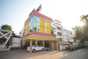 a building with a car parked in front of it at HOTEL ABHISHEK, Shirdi in Shirdi