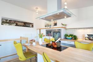 a kitchen with a dining table and yellow chairs at Eicher Ferienwohnungen Warnemünde in Warnemünde