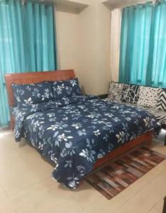a bedroom with a bed with a blue comforter at The Layover Condotel ,Palm Tree two Villas ,cluster 2 - unit 7q , New Port Boulevard , Newport City ,NAIA Terminal 3 , Pasay City , Philippines in Sampong +8 photos