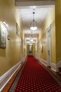 an empty hallway with a red carpet in a building at The Marshall House, Historic Inns of Savannah Collection in Savannah