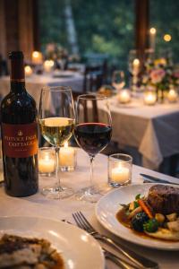 a table with two glasses of wine and a plate of food at Plitvice Falls Cottage - Luxury rooms & Dinner in Plitvica Selo +54 photos