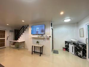 a living room with a flat screen tv on a wall at NB Bangsaen House in Ban Puk (2) +16 photos
