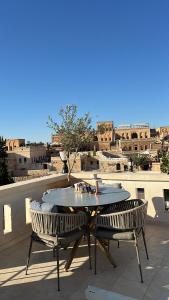 a table and chairs on a patio with a view of a city at Zenobia Otel in Midyat