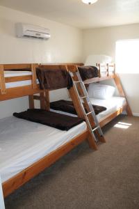 a room with three bunk beds in a hostel at Pipestem Spa, Event Center and Mountain Chalets in Pipestem