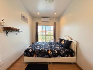 a bedroom with a bed and a window at NB Bangsaen House in Ban Puk (2)