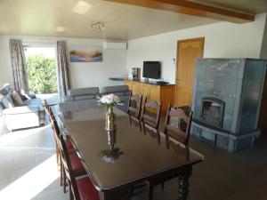 a dining room and living room with a table and a fireplace at 'T Lang Zweerd in Middelkerke