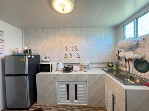 a small kitchen with a refrigerator and a sink at NB Bangsaen House in Ban Puk (2)