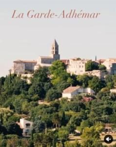 a town on top of a hill with trees at Studio décoré avec goût in Saint-Paul-Trois-Châteaux