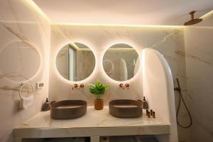 two sinks in a bathroom with two mirrors at Aerial Apartments in Karterados +10 photos