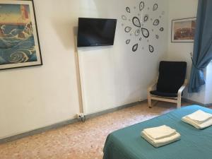 ローマにあるDelightful apartment 100 meters from the Colosseumのベッド1台と壁掛けテレビが備わる客室です。