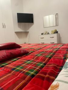 a bedroom with a bed with a red and green blanket at Irnohouse in Salerno