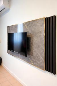 a flat screen tv hanging on a wall at Neela House in Labuan