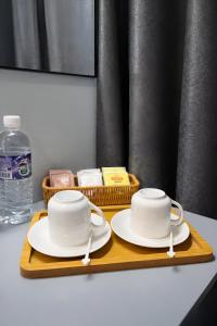 a tray with two cups and plates on a table at Neela House in Labuan