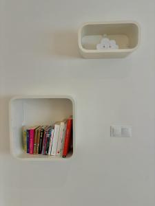 a bookcase with a shelf with books in it at Maison Les Sardines in Cucq