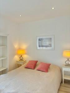 a bedroom with a bed with two red pillows on it at Maison Les Sardines in Cucq