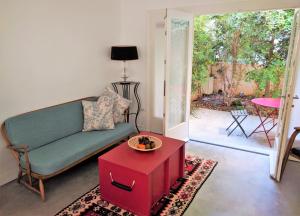 sala de estar con sofá verde y mesa roja en Designer Bauhaus, en Tel Aviv