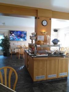 a kitchen with a counter with a clock on the wall at Landhaus Hotel Müller in Ringheim