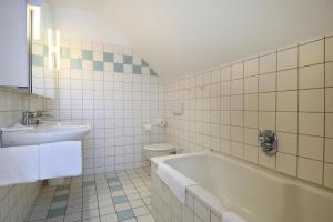 a bathroom with a sink and a tub and a toilet at Appartements Post Hiddensee, Vitte in Vitte