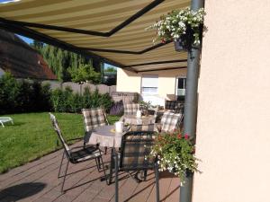 a patio with a table and chairs under a canopy at Landhaus Hotel Müller in Ringheim