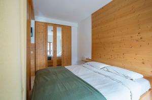 a bedroom with a large bed with a wooden wall at Il Nido di Somadino in Casargo