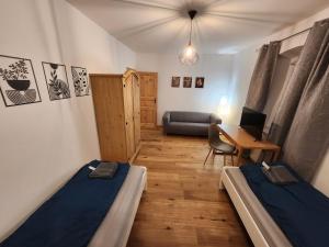 a room with two beds and a desk with a laptop at Bachhaus Marktredwitz Haupthaus in Marktredwitz