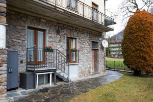 a stone house with a porch and a balcony at Il Nido di Somadino in Casargo