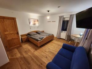 a bedroom with a bed and a blue couch at Bachhaus Marktredwitz Haupthaus in Marktredwitz