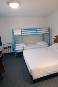 two beds in a room with two bunk beds at Quick Palace Saint Brieuc in Tregueux