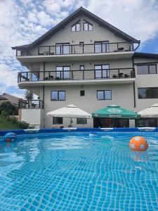 a hotel with a swimming pool in front of a building at PENSIUNEA OCTAVIAN in Horezu