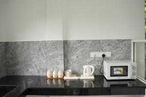 a kitchen with a microwave and a coffee machine at Meadow Breeze in Kandy