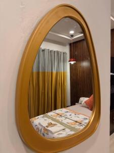 a mirror on a wall with a bed in a room at Mihira Homestays in Hanamkonda