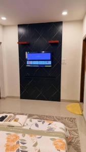 a living room with a tv on a black wall at Mihira Homestays in Hanamkonda
