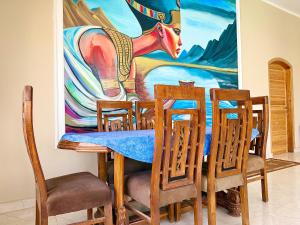 a dining room with a table and a painting of a cow at Citadel Luxor in Luxor