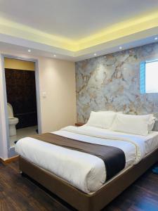a bedroom with a large bed with a stone wall at Heranya Taleju in Kathmandu