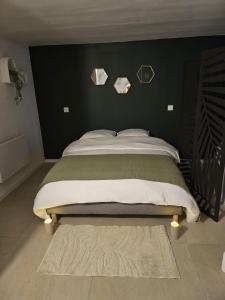 a bedroom with a bed with a green wall at Suite 11 in Tourcoing