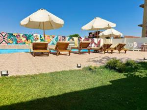 a group of chairs and umbrellas next to a pool at Citadel Luxor in Luxor